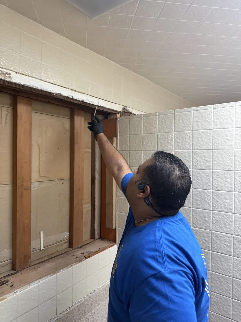 My Water Damage Hero technician probing an opened wall cavity during a water damage assessment